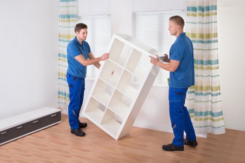 Trained removals staff carrying furniture carefully in a hallway
