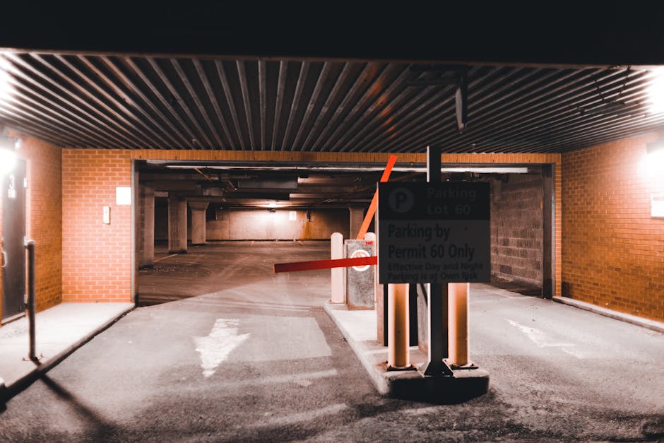 The image shows the entrance to an underground parking garage within a residential or commercial building, featuring a black and white sign indicating parking regulations for permit holders only, spec